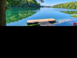 wooden dock extending in to a lake on a summer day