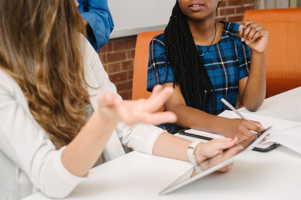 two women at a table discussing work